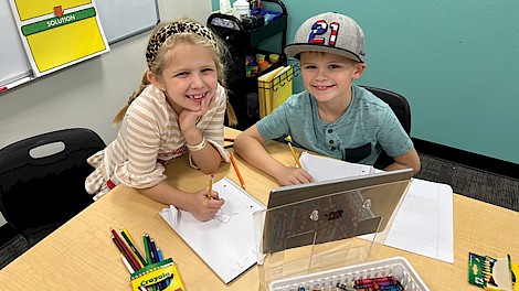 Aslyn Jackson and Boston Barr watching and writing in their journals in a reading station at Legacy COOP. photo by Amanda Barr