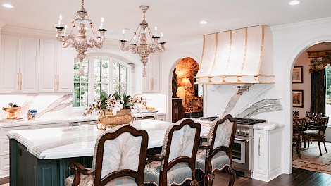 =Bold marble veining and stacked-edge stone countertops bring striking definition to the design.