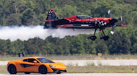A Precision Exotics McLaren takes on a stunt plane in a high-speed “car vs. plane” runway race similar to what audiences will experience at the TXK Airshow on June 27. photo by Steven Holzinger of Zinger Aviation Media