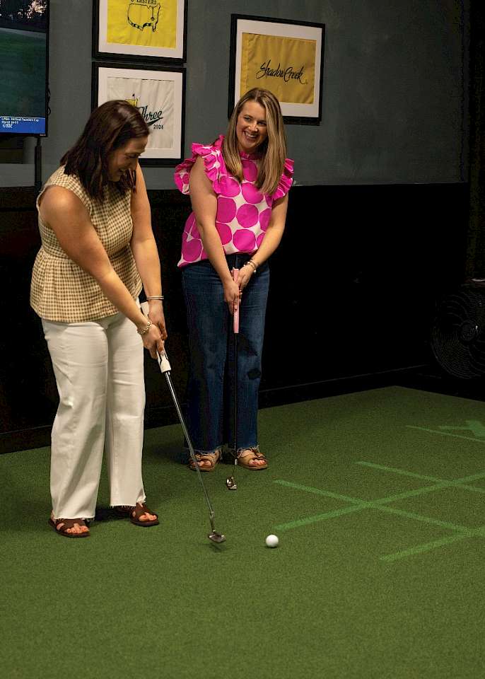 Shelby McElhany and Joy Sandefur  compete in a game of tic-tac-toe  at Tee It Up Golf Lounge.